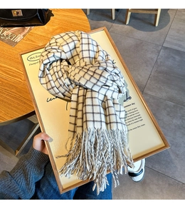 Detail shot of black and white checkered winter scarf with elegant fringe tassels