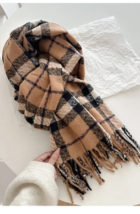 Close-up of a warm thick plaid scarf with tassels in brown and white on a clean background