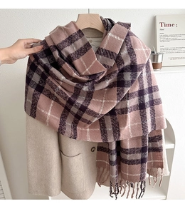 Detail of pink plaid tassel scarf with soft cashmere-like texture on a coat