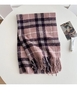Close-up of thick plaid scarf with tassels in dusty pink and purple on a white table