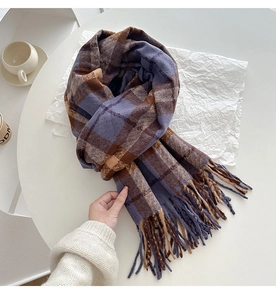 Detailed view of the thick vintage plaid scarf with blue and brown weave and soft fringe