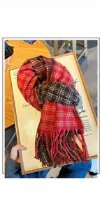 Close-up of thick red and black checkered cashmere-feel scarf with long fringe details