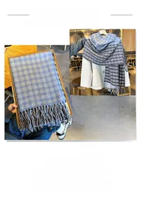 Close-up of blue and grey checkered scarf texture with fringe details on wool coat