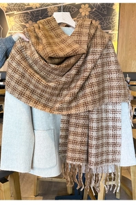 Close-up of thick winter scarf with brown and beige checkers and fringe detail
