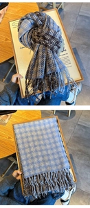 Close-up of thick blue and brown plaid scarf with long fringe tassels in a wooden tray