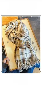 Close-up of classic plaid scarf with soft fringe tassels and cashmere-like texture