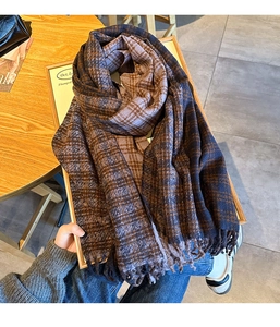 Detailed close-up of retro plaid scarf with soft fringe trim in navy and brown colors
