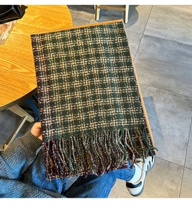 Close-up of retro plaid scarf with deep green and brown patterns and long tassels