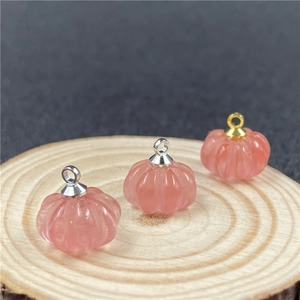 Vista macro di ciondoli a forma di zucca in quarzo fragola rosa su base in legno