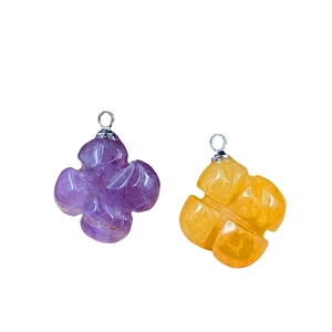 Purple and yellow amethyst clover flower pendants with silver metal rings on white background