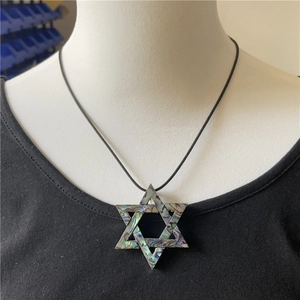 Detail of abalone shell hexagram star pendant with natural blue and green textures
