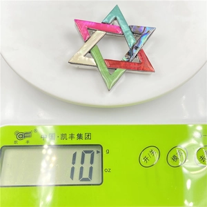 Macro shot of a 10g abalone shell star brooch showing weight on an electronic scale
