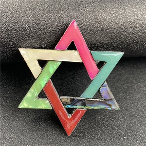 Macro shot of colorful geometric hexagram brooch with iridescent abalone shell inlay