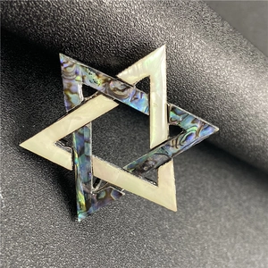 Macro view of abalone and mother of pearl inlay on hexagram star pendant brooch