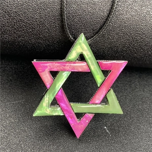 Macro detail of hexagonal star pendant with pink and green abalone shell textures