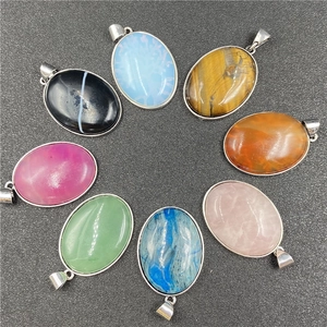 Vue de dessus de huit pendentifs ovales en pierres fines avec bords en métal poli