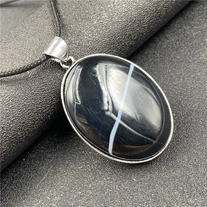 Vue macro du pendentif ovale en agate arbre de vie avec rayure blanche naturelle