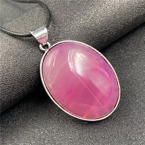 Vue macro détaillée du pendentif en agate rose avec bélière en argent et cordon noir