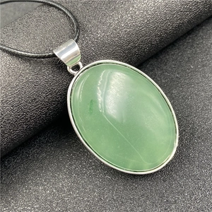 Vue macro du pendentif ovale en agate verte avec monture argentée et cordon noir