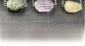 Close-up of geometric faceted amethyst and citrine crystal pendants on a silver chain