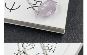 Close-up of hexagonal purple amethyst crystal pendant with a sleek silver-tone chain