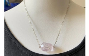 Close-up of faceted light purple amethyst pendant necklace on a jewelry mannequin