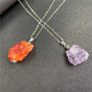 Close-up of irregular amethyst and carnelian raw stone pendants on thin silver chains