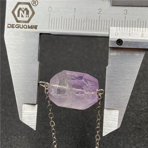 Faceted amethyst pendant necklace with silver chain shown with a caliper for size measurement