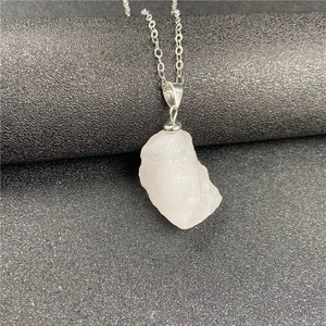 Detail of raw white crystal pendant with natural texture and silver chain necklace
