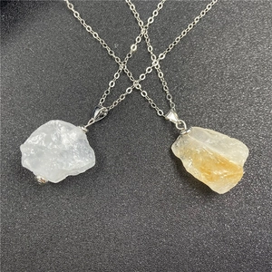 Close-up of geometric natural white and yellow crystal stone pendants on silver chains