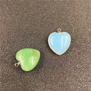 Close-up of heart-shaped opal and jade pendants with silver loops for DIY necklace
