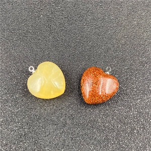 Macro shot of heart-shaped natural stone pendants in yellow and glittery brown goldstone