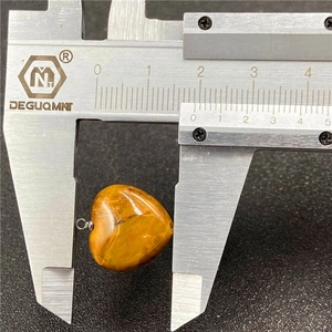 Detailed measurement of heart-shaped tiger's eye stone pendant showing 20mm width on caliper
