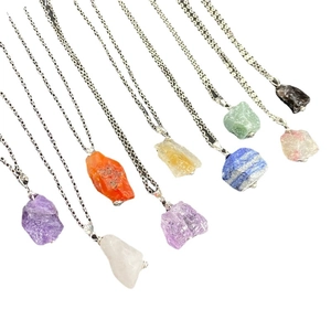 Multiple geometric raw natural gemstone pendants on silver chains in assorted colors