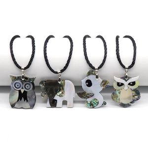 Detailed view of four animal shell pendants including owl, elephant and panda with cords