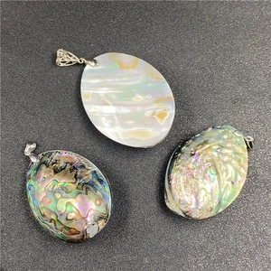 Macro shot of oval abalone shell pendants with vibrant rainbow texture and silver bails