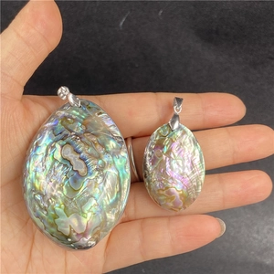 Detailed comparison of two natural abalone shell oval pendants with iridescent luster