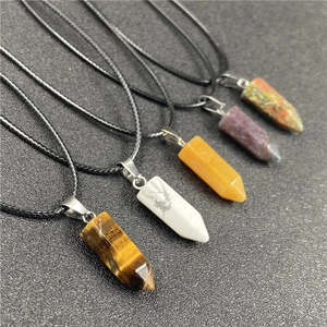 Detail view of five different hexagonal natural stone pendants with simple black cord necklaces