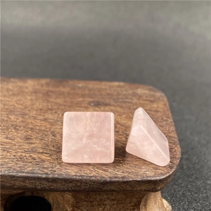 Dettaglio macro di pietre di quarzo rosa quadrate con texture naturale su legno