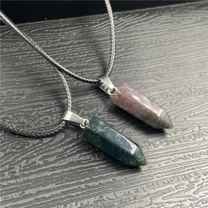 Detailed macro view of two hexagonal crystal pendants in dark green and deep reddish brown stone