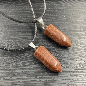 Detail of two hexagonal goldstone crystal pendants with silver clasps on black cords