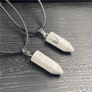 Detail showing two hexagonal white turquoise pendants with silver clasps on black ropes