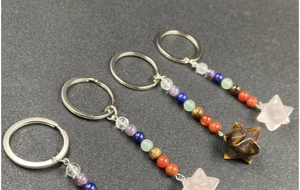 Dettaglio di portachiavi con cristalli sette chakra e pendenti a stella Merkaba in pietra
