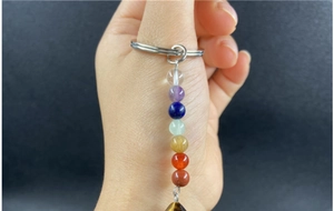 Dettaglio di un portachiavi dei sette chakra con perle colorate e anello argento