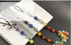 Detail of seven chakra natural crystal beads and stones on a hand-woven car ornament