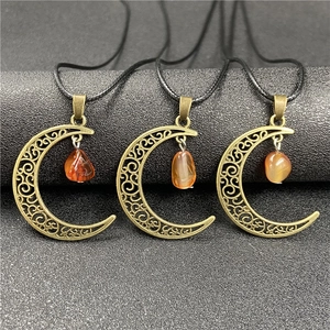 Three bronze hollow moon necklaces with amethyst and carnelian stones on grey background