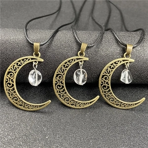 Detail of three bronze moon pendants with clear raw crystals on black wax cords