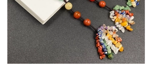 Macro view of woven hanging ornament featuring colorful natural crystal beads on black texture