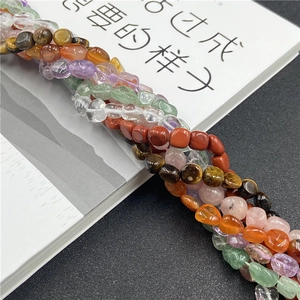 Detailed close-up of mixed natural tumbled stones including amethyst and agate beads