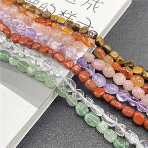 Close-up of polished irregular amethyst and rose quartz crystal beads for DIY jewelry